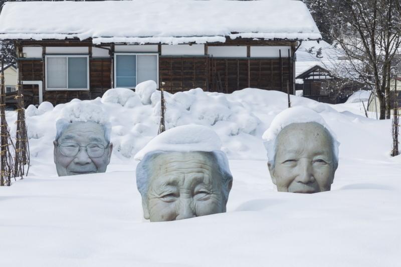 タイトル「いい顔になったれ！」と名付けられた積もる雪の中で石像の頭が出ている写真