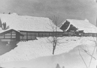 屋根に多量の雪が積もった古い映画館の写真