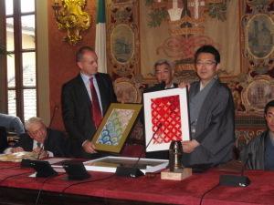 35周年記念式典で着物を着た関口芳史市長が贈呈品を見せている写真