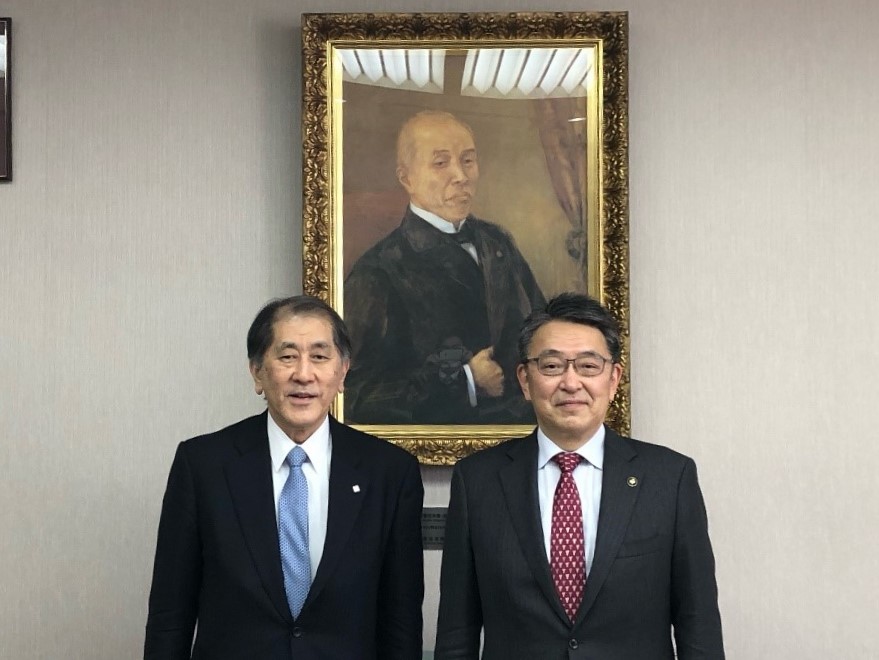 大隈重信初代総長の肖像画の前で撮影した田中総長と市長の写真