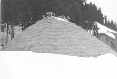 ピラミッド型に積んだ雪を藁でしっかりと周りを囲っている写真