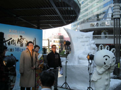 ネージュくんと雪像の横で関口市長が話している。