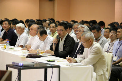 会場の座席に座って話をする関口市長。