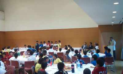 会場内のテーブルにたくさんの子供たちが着席している。