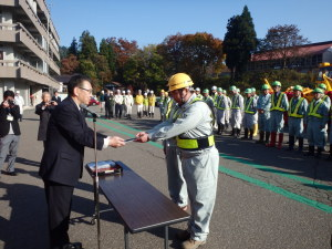 会場前方で作業員と関口市長がお辞儀をしている。