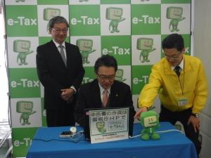 係の方に説明を受けながら、実際にe-TAX(イータックス)を使って確定申告を行う市長の写真