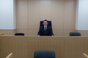 法廷の内覧にて裁判長席に座る市長の写真