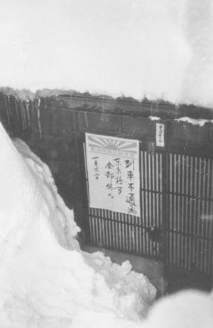 大量の雪の中で新聞配達できない為、休刊を告げる新聞店入口の当時の写真