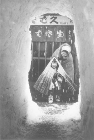 玄関先の雪を掘ってトンネルを作り往来をしている当時の写真