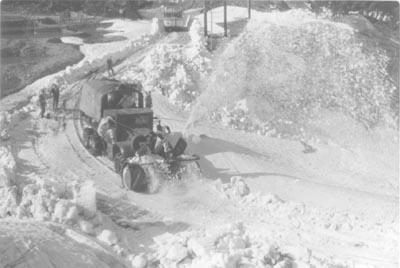 初期型の道路除雪機が雪を取り込み上に放射している当時の写真