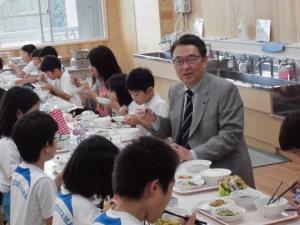 新しいランチルームで、児童と一緒に給食を試食する市長の写真