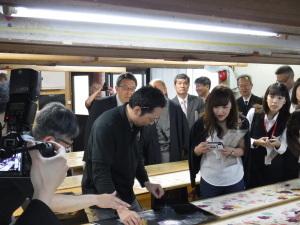 きもの工場内の板場における、型付の工程を見学する市長たち参加者の写真