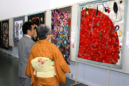コンテスト作品を鑑賞する関口市長とキルト展実行委員会顧問の田村恭子さん。