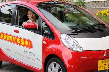 関口市長が赤色の電気自動車に試乗している。