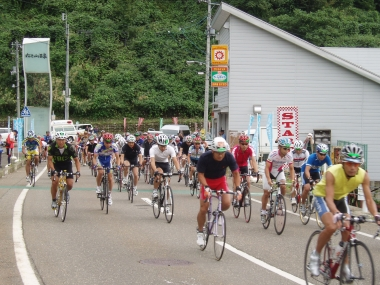 道路を自転車で走行するたくさんの選手たち。