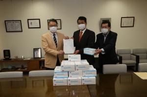 新潟第一酒造株式会社役員より不織布マスクを受領する市長の写真