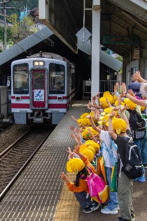 園児が電車に手を振っている様子