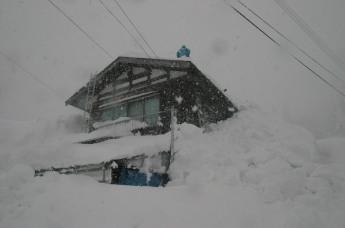 ほぼ雪に覆い尽くされてしまった民家の写真