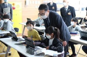 授業支援ソフト活用授業視察において子どもたちのタブレット端末の操作を見ている市長の写真