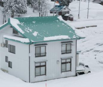 雪が滑り落ちて屋根に殆ど残っていない落屑式住宅の様子の写真