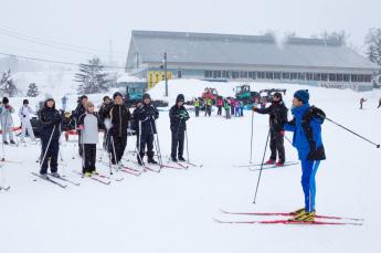 スキーの授業を受けている小学生たちの写真