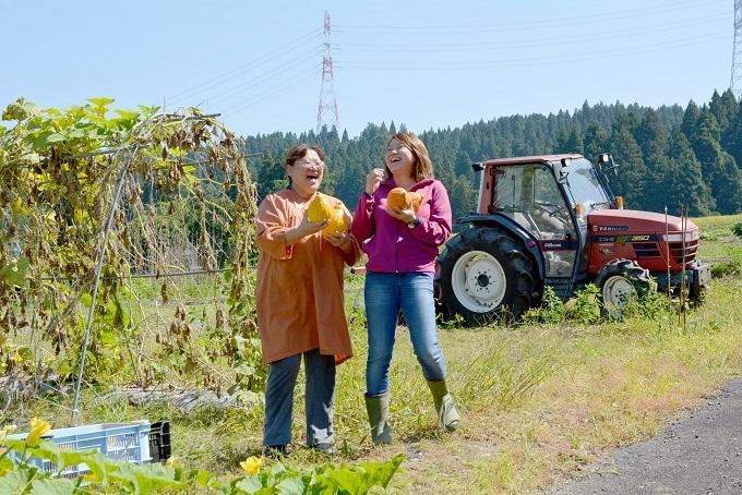 福嶋恭子さんとその娘さんが手に農作物を持って笑っている写真