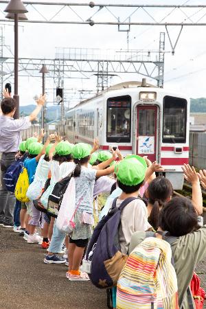 園児が電車に手を振っている様子