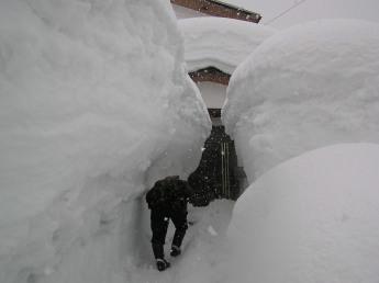 積もった雪に覆われてしまいそうな玄関の写真