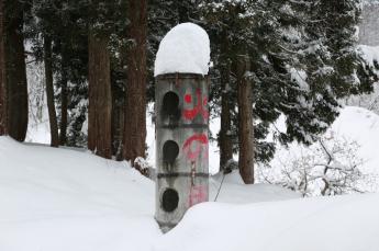 雪に埋もれても大丈夫な高さの円柱型のコンクリート製の消火栓の写真
