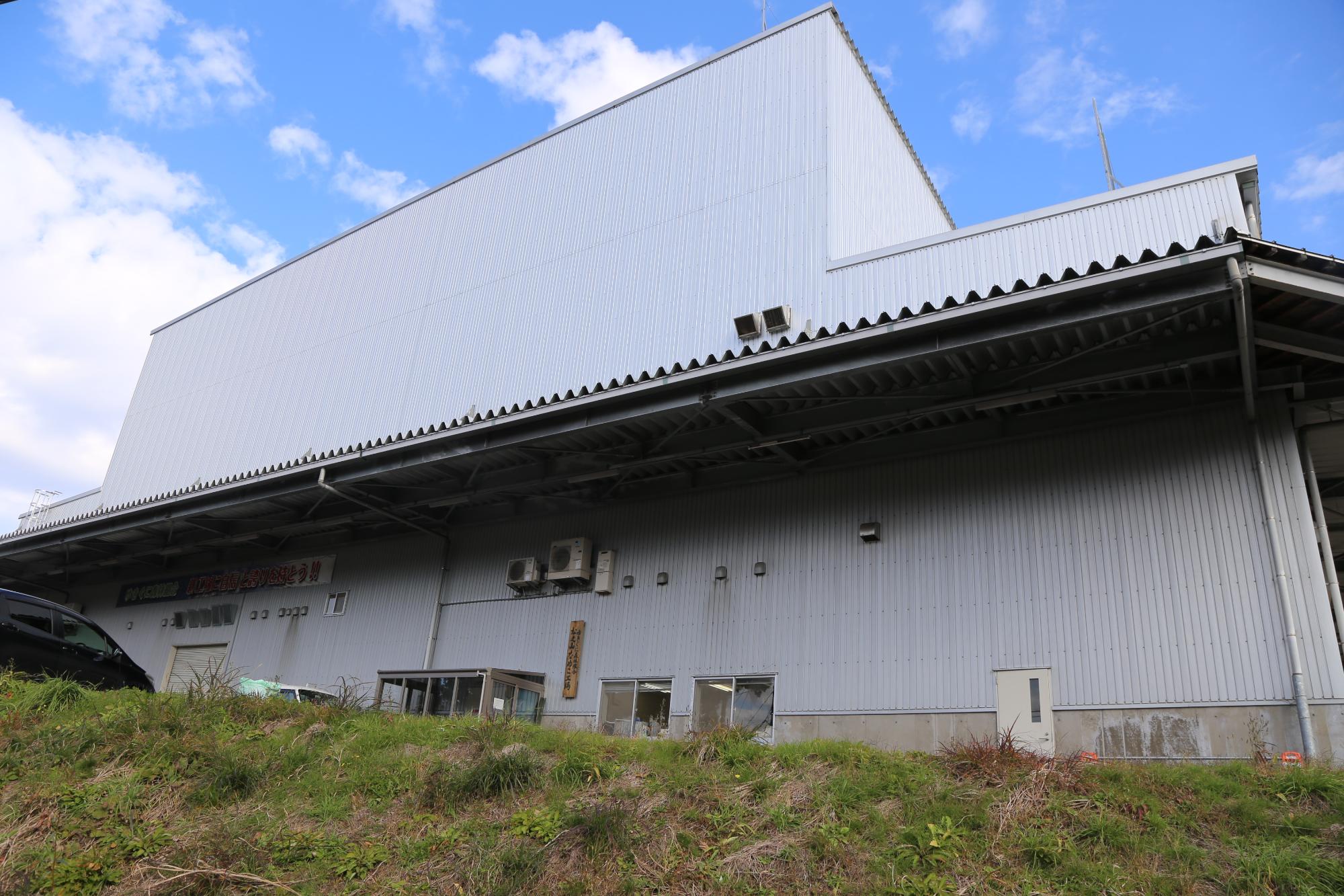 青空の下、白い大きな工場が建っている