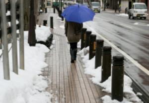融雪式歩道のおかげで歩道の真ん中に雪がない状態となっている様子の写真