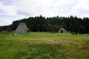 草原と山に囲まれた中に特徴的な形をした建物が2つ見える写真