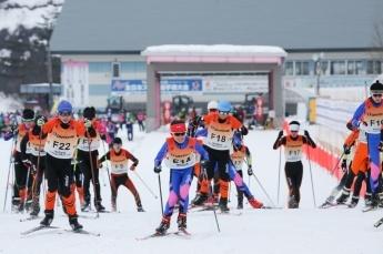 スキー板とストックを身につけた選手たちがコースを進んでいる写真