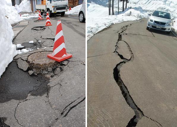 地震で液状化で浮き上がるマンホールと、亀裂の入った道路の写真