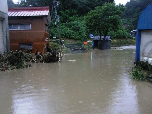 河川が氾濫して民家が浸水、一面川のようになっている所の写真